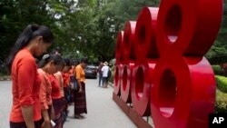 Members of National League for Democracy party show their respect in front of the numbers "8888", during a ceremony marking the 30th anniversary of the pro-democracy uprising, Aug. 8, 2018, in Yangon, Myanmar.