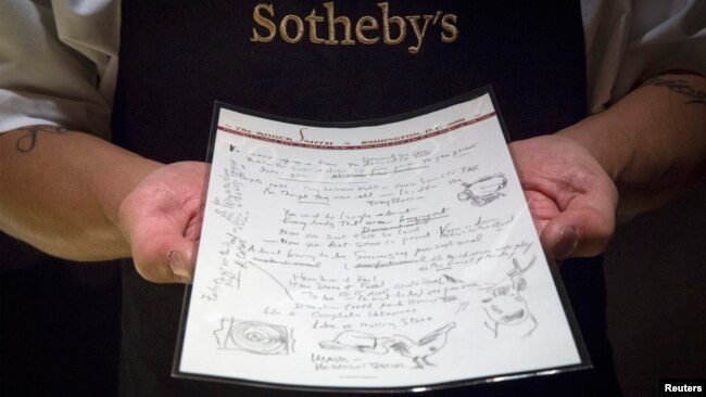 A Sotheby's employee shows the handwritten lyrics for Bob Dylan's 'Like a Rolling Stone' song that is part part of a collection from; 'A Rock and Roll History: Presley to Punk' at Sotheby's auction house in New York, June 20, 2014.