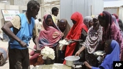 Women and children from southern Somalia line up to receive cooked food distributed by World Food Program (WFP) in Mogadishu, Somalia, August 20, 2011.