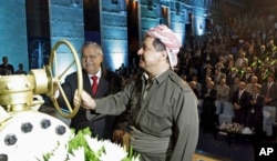 FILE - Kurdish President Massud Barzani (r) and Iraqi President Jalal Talabani open a ceremonial valve during an event to celebrate the start of oil exports from the autonomous region of Kurdistan, in the northern Kurdish city of Irbil, Iraq, June 1, 2009