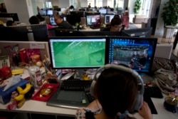 資料照：中國電遊開發公司的員工觀看屏幕上顯示的電遊“光榮使命”。 （2013年8月2日）