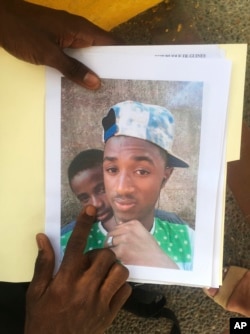 Mamadou Aliou Barry, who departed from his native Guinea in West Africa when he was 14, a few years ago, shows a print of a selfie with his friend while waiting for entry to the U.S. on the Gateway Bridge in Matamoros, Mexico, which connects to Brownsville, Texas, July 3, 2018. He said as part of the minority ethnic Fula group, he fears for his life and carries this picture of him and a friend together and another picture of his friend after he was slain, for his asylum interview.