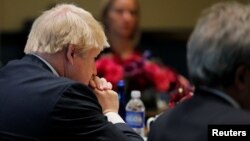 FILE - United Kingdom Foreign Secretary Boris Johnson (L) and European Union High Representative Federica Mogherini (rear) listen as United States Secretary of State John Kerry speaks during a meeting of foreign ministers from Germany, the UK, France, Ita