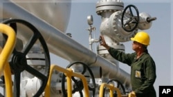Iranian oil technician Majid Afshari, checks the oil separator facilities in Azadegan oil field, some 480 miles (800 kilometers) southwest of the capital, Tehran, Iran, Tuesday, April 15, 2008.