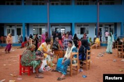 People relocated to a school building because of an overnight gunbattle between troops and suspected Islamist militants on the east coast of Sri Lanka are seen in Kalmunai, April 27, 2019.