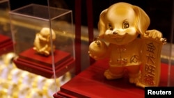 Dog-shaped gold figurines are displayed at Chow Tai Fook Jewellery store ahead of the Lunar Year of the Dog in Hong Kong, China December 14, 2017. But in Malaysia, some businesses are avoiding dog symbols in their decorations. They do not want to insult the country’s Muslim majority. (REUTERS/Tyrone Siu)