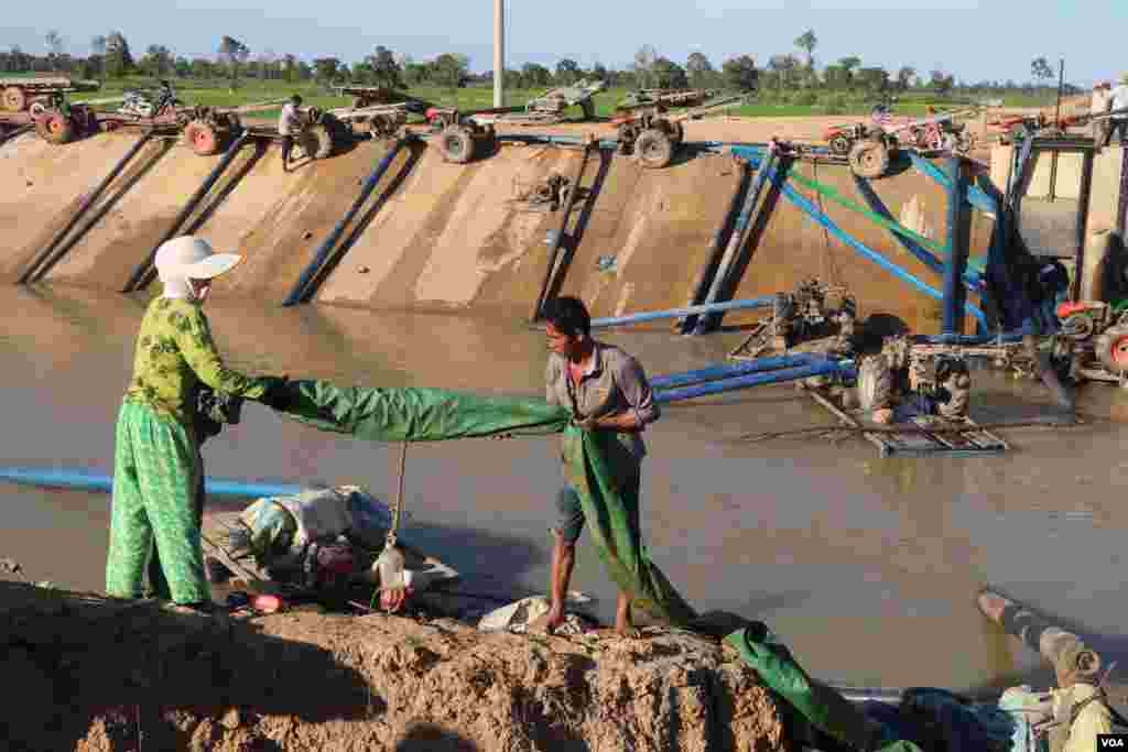 កសិកររៀបចំទុយយោបូមទឹកពីប្រឡាយមេក្នុងឃុំត្រពាំងជង ស្រុកបាកាន ខេត្តពោធិ៍សាត់ ។ (ស៊ុន ណារិន/VOA Khmer)