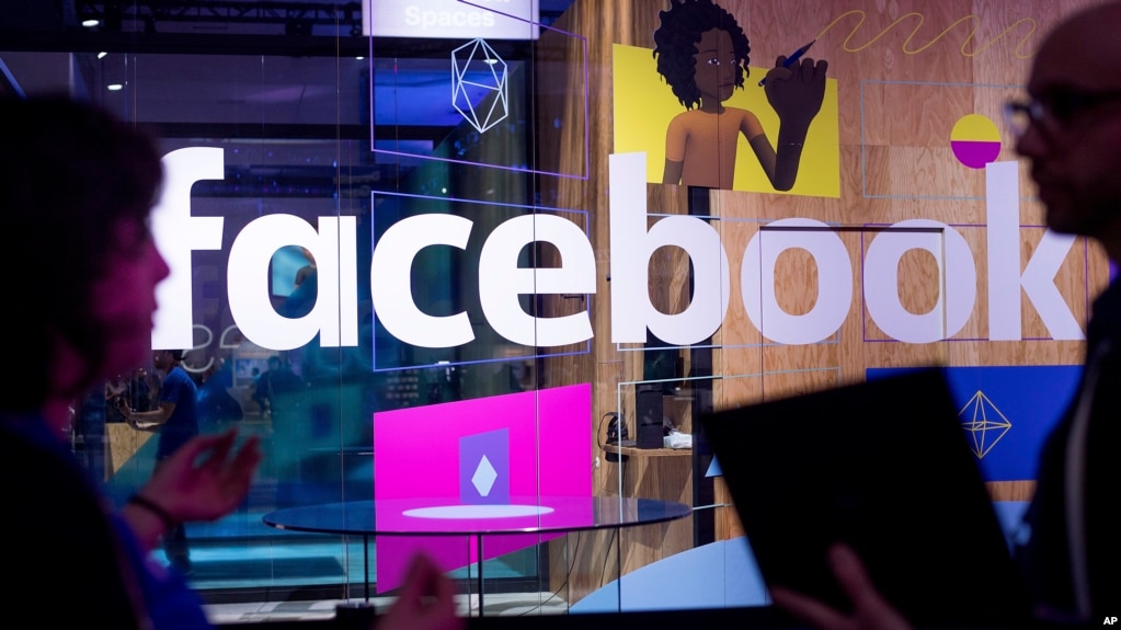 FILE - Conference workers speak in front of a demo booth at Facebook's annual F8 developer conference, in San Jose, California, April 18, 2017.