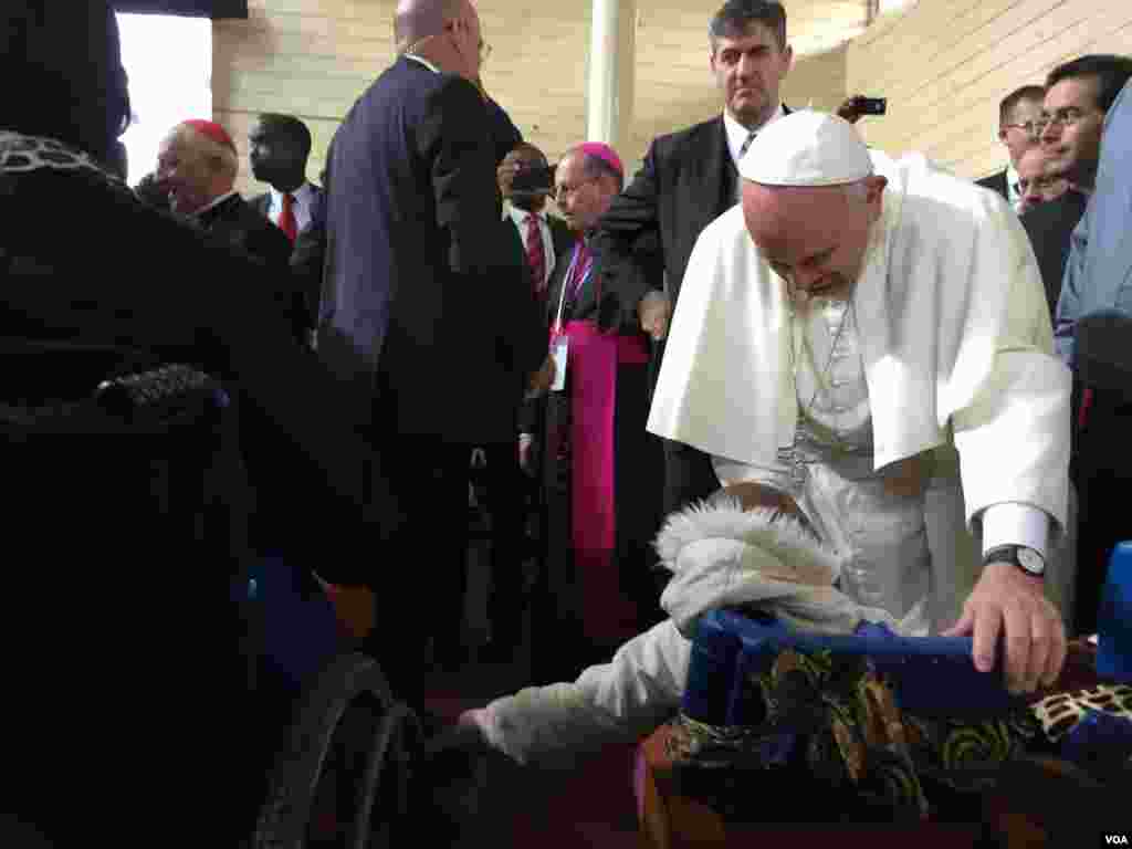 The Pope greeting a child in a wheelchair in Kangemi, Nov. 27, 2015. (J. Craig/VOA)