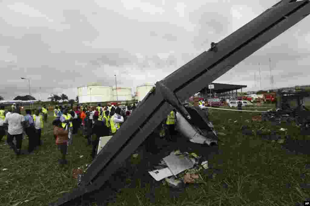 Rescue workers gather around the wreckage of a charter passenger jet that crashed soon after take off from Lagos airport, Nigeria, Oct. 3, 2013.
