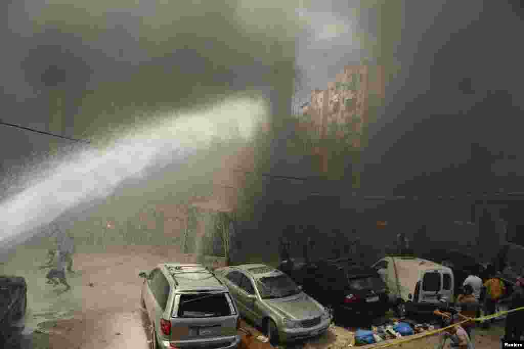 Civil Defense members extinguish fire at the site of an explosion in Beirut's southern suburbs, July 9, 2013.