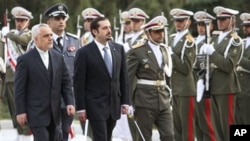 Lebanese Prime Minister Saad Hariri, center left, reviews an honor guard as he is accompanied by Iranian Vice-President Mohammad Reza Rahim, left, during an official welcoming ceremony, in Tehran, Iran, 27 Nov 2010