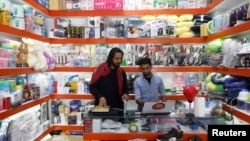 Afghan shopkeepers work on their laptop at their online shop in Kabul, Afghanistan, June 4, 2018. 