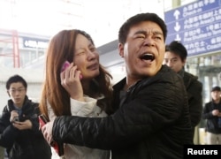 A relative of a passenger onboard Malaysia Airlines flight MH370 cries as she talks on her mobile phone at the Beijing Capital International Airport, China, Mar. 8, 2014.