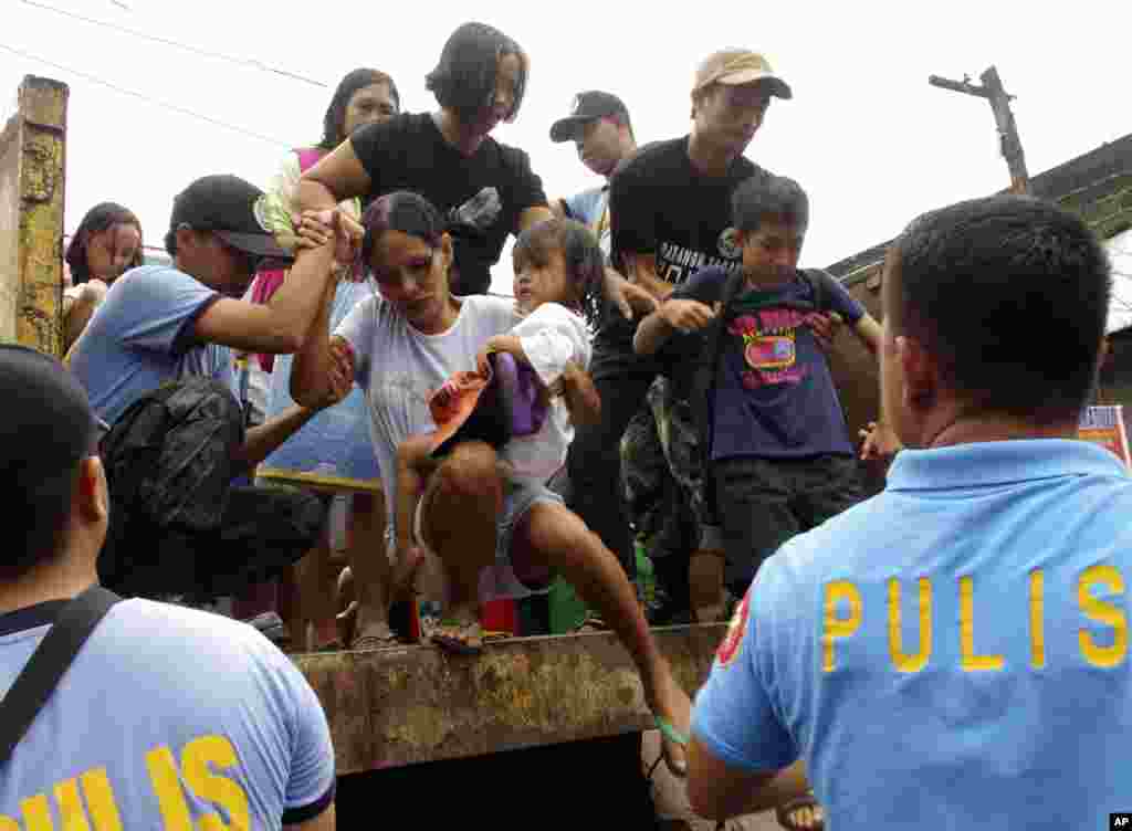 Residents living near the slopes of Mayon volcano are evacuated to public schools by police in ahead of Typhoon Haiyan, Philippines, Nov. 7, 2013.