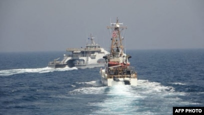 Kapal Angkatan Laut Iran (IRGCN) Harth 55 (kiri) melintasi haluan kapal patroli Coast Guard USCGC Monomoy (WPB 1326) (kanan) saat sedang melakukan patroli keamanan maritim rutin di perairan internasional Teluk Arab selatan, 2 April 2021. (Foto: Angkatan Laut AS/AFP)