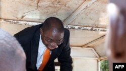 FILE - Malawi’s former Justice Minister Ralph Kasambara gets out of a police vehicle upon his arrival at the Lilongwe Chief Resident Magistrate Court, on Nov. 11, 2013.
