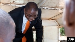 FILE - Malawi’s former Justice Minister Ralph Kasambara gets out of a police vehicle upon his arrival at the Lilongwe Chief Resident Magistrate Court, Nov. 11, 2013. 