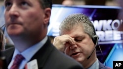 FILE - Trader John Panin, right, works on the floor of the New York Stock Exchange, Oct. 17, 2016. By the end of the week, the Dow Jones Industrial Average had rebounded from a triple-digit loss.