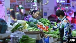 2021年11月1日，中国广西南宁某菜市场一位顾客在购买蔬菜。