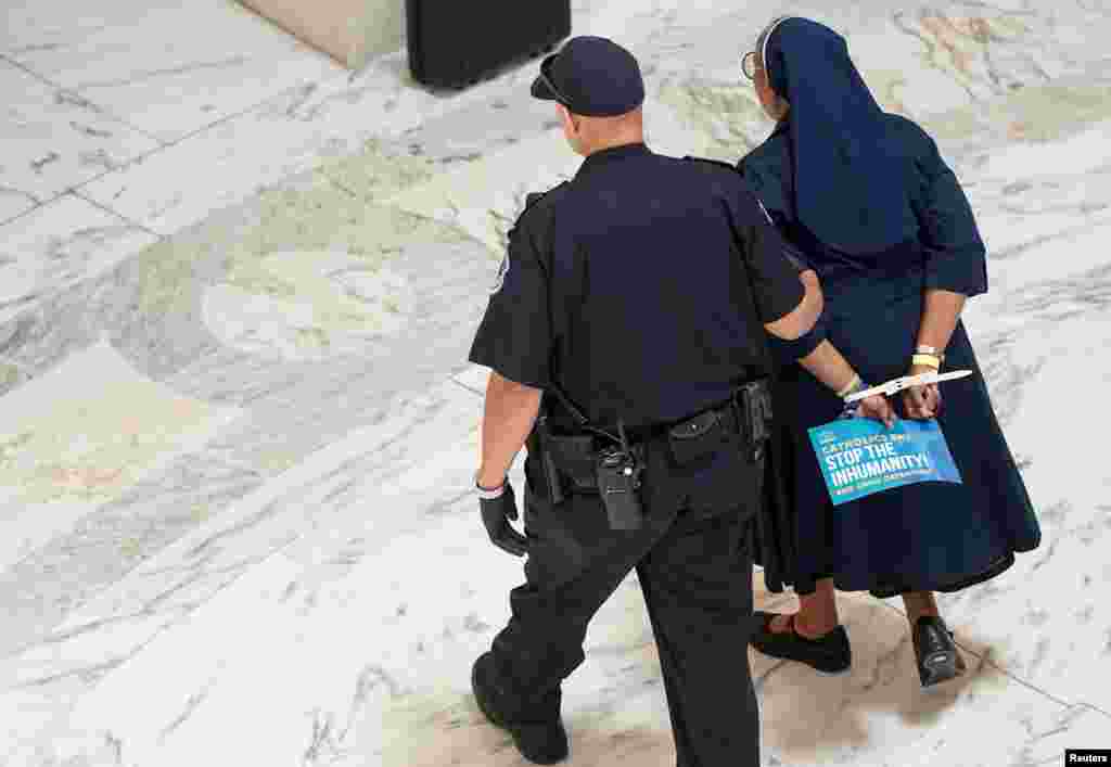 One of a members of the Franciscan Action Network and immigration rights activists is arrested during a demonstration calling for the end of immigrant detention on Capitol Hill in Washington.