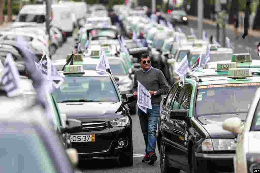 A taxi driver prepares to take part in a slow convoy in Lisbon, Portugal to protest against cab giant Uber, which they accuse of illegally undercutting their business. Between 3,000-4,000 cabbies were participating, according to two industry bodies organizing the protest.
