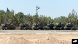 Turkish tanks stationed near the Syrian border, in Karkamis, Turkey, Saturday, Sept. 3, 2016. Turkey's state-run news agency says Turkish tanks have entered Syria's Cobanbey district northeast of Aleppo in a "new phase" of the Euphrates Shield operation. 