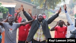 Mains levées, quelques manifestants essaient d’entamer une marche avant d’être dispersés à Lomé, Togo, 19 août 2017. (VOA/Kayi Lawson)