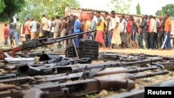 FILE - Suspected fighters are paraded before the media by Burundian police near a recovered cache of weapons after clashes in the capital, Bujumbura, Dec. 12, 2015. 