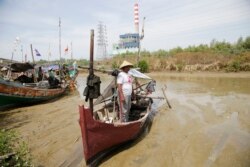 Seorang nelayan berdiri di dekat kapalnya di sungai dekat pembangkit listrik di Cirebon, 18 Oktober 2014. (Foto: Ilustrasi/Reuters)