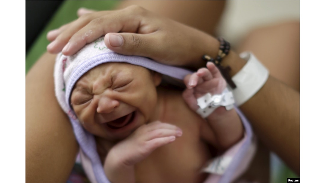 Sueli Maria (obscured) holds her daughter Milena, who has microcephaly, (born seven days ago), at a hospital in Recife, Brazil, Jan. 28, 2016.