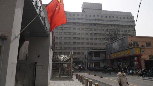 一名戴着口罩的女子走过北京复兴医院。(2020年2月21日)