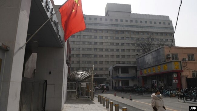 一名戴着口罩的女子走过北京复兴医院。(2020年2月21日)