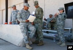 Arizona National Guard soldiers receive their reporting paperwork prior to deployment to the Mexico border at the Papago Park Military Reservation in Phoenix, April 9, 2018.