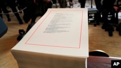FILE - Pages of a spending bill are stacked on a table in the Diplomatic Room of the White House in Washington, March 23, 2018.