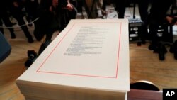 FILE - A copy of a $1.3 trillion spending bill is stacked on a table in the Diplomatic Room of the White House in Washington, March 23, 2018. 