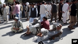 Afghan protesters sit on the ground to block one of the main Kabul streets during a demonstration against the government, in Kabul, Afghanistan, Oct. 7, 2015. 