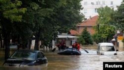Firefighters evacuate people on a boat in the flooded town of Obrenovac, May 18, 2014.