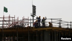 Des migrants travaillent sur un site de construction à Doha, Qatar, le 26 mars 2016.