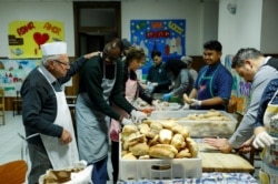 Dino Impagliazzo, Rome's 90-year-old 'chef of the poor', greets volunteers as they make sandwiches for the homeless living in the city.