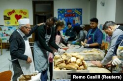 Dino Impagliazzo, Rome's 90-year-old 'chef of the poor', greets volunteers as they make sandwiches for the homeless living in the city.