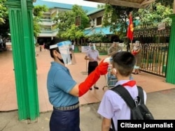 ການກວດ​ອຸນ​ຫ​ະ​ພູມ​ນັກ​ຮຽນ​ເພື່ອ​ກັນຄວາມ​ສ່ຽງ​ໃນ​ການ​ຕິດ​ໂຄວິດ-19 ໃນ​ໂຮງ​ຮຽນ​ມັດ​ທະ​ຍົມ​ແຫ່ງ​ນຶ່ງ​ຢູ່​ນະ​ຄອນ​ຫລວງ