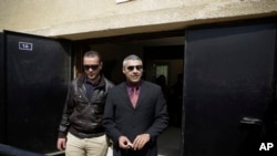 Al-Jazeera English journalists Canadian Mohamed Fahmy, right, and Egyptian Baher Mohammed leave a court after a hearing in their retrial near Tora prison in Cairo, Egypt, March 8, 2015.