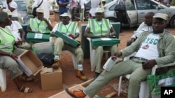 Electoral officials wait for ballot material at the distribution center in Ibadan, Nigeria, Saturday, April 2, 2011