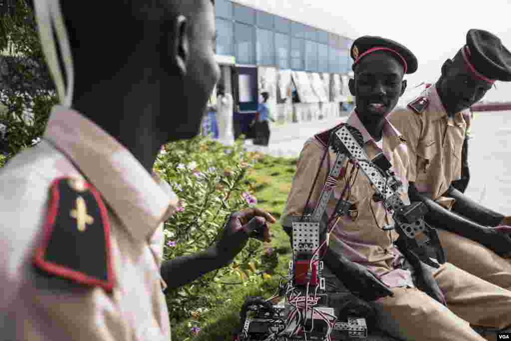 Mamadou Sarr Lo, far left, 17, from the Prytanee Military school in St. Louis, Senegal, chats with his teammate as they look at their robot at the 2017 Pan-African Robotics Competition in Dakar, Senegal, May 19, 2017. (R. Shryock/VOA)