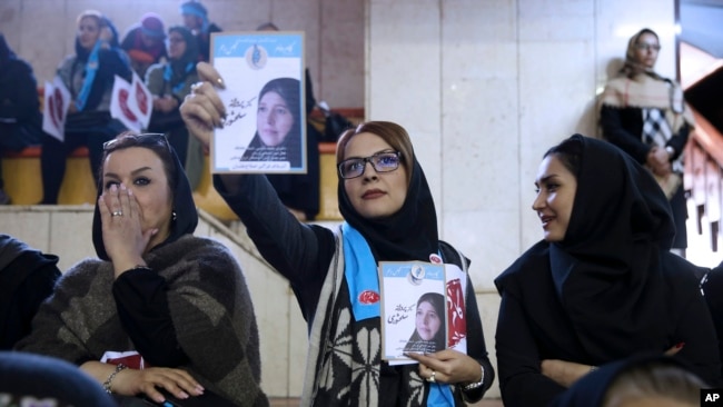 FILE - An Iranian woman holds leaflets showing Parvaneh Salahshouri, a candidate in parliamentary elections, during a reformists campaign rally in Tehran, Iran, Feb. 18, 2016.