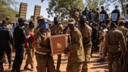 Des responsables militaires portent un cercueil dans la section militaire du cimetière de Gounghin à Ouagadougou le 23 novembre 2021 d'un militaire burkinabé tué lors de l'attaque d'un camp de gendarmerie à Inata le 14 novembre 2021.