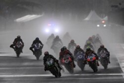 Pembalap mengendarai sepeda motor di tengah hujan lebat menjelang Race 2 Kejuaraan Dunia Superbike di Sirkuit Jalan Internasional Mandalika di Lombok, Nusa Tenggara Barat, 21 November 2021. (Foto: Antara/Sigid Kurniawan via REUTERS)