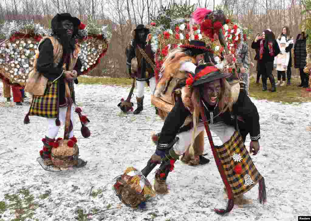 Local residents dressed in costumes perform during celebrations for Malanka traditional holiday, which is celebrated on the day of St. Basil and St. Melania, in the settlement of Krasnoilsk in Chernivtsi Region, Ukraine.