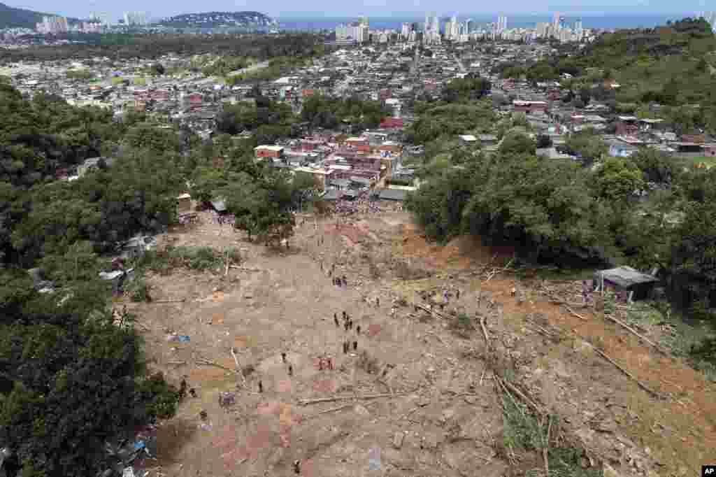 Rescue workers, residents, and volunteers search for victims after a mudslide caused by heavy rains in the coastal city of Guaruja, Brazil.